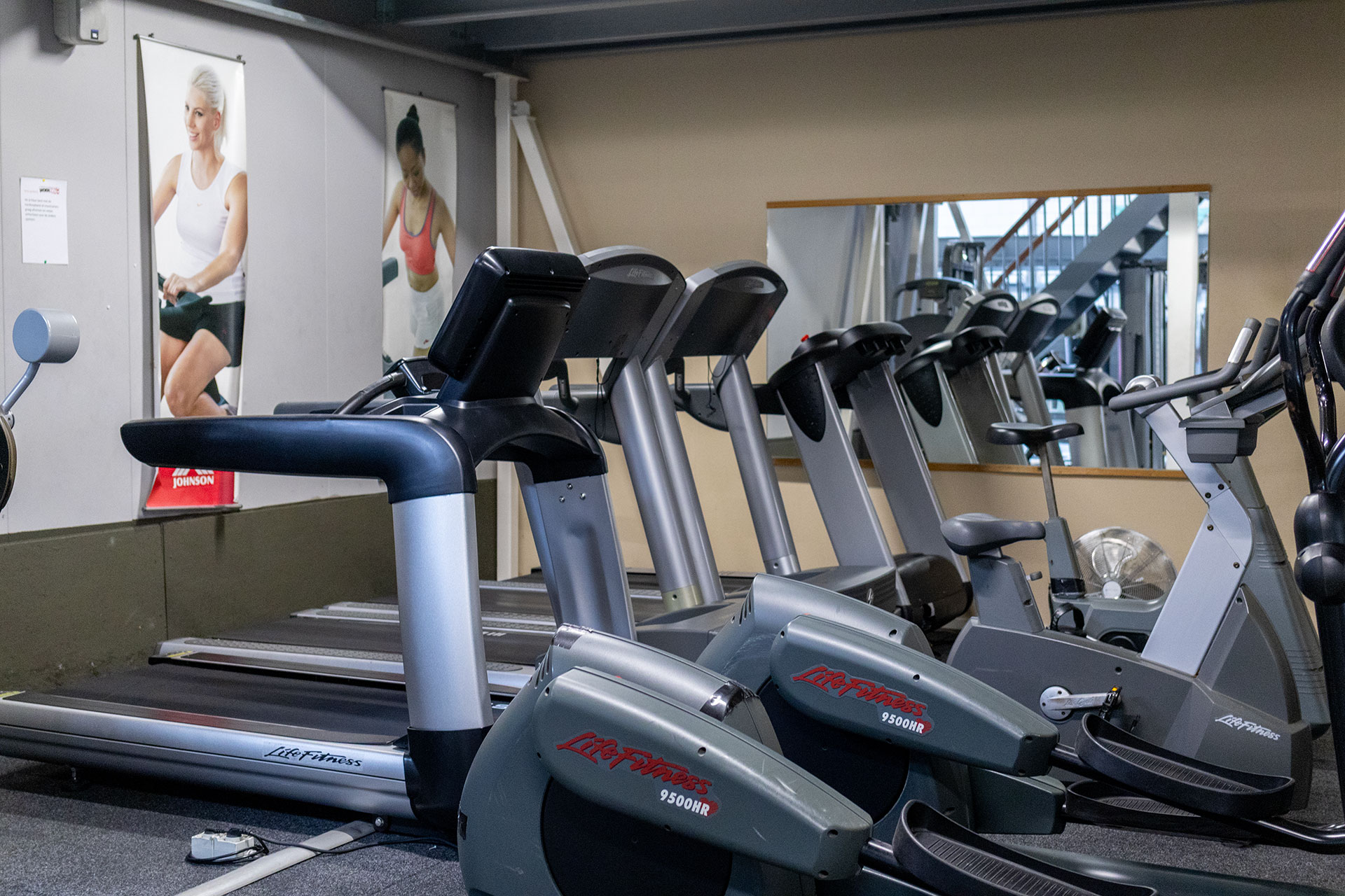 Cardioruimte met loopbanden, hometrainers en fitnessapparatuur bij Sportcentrum Woerden